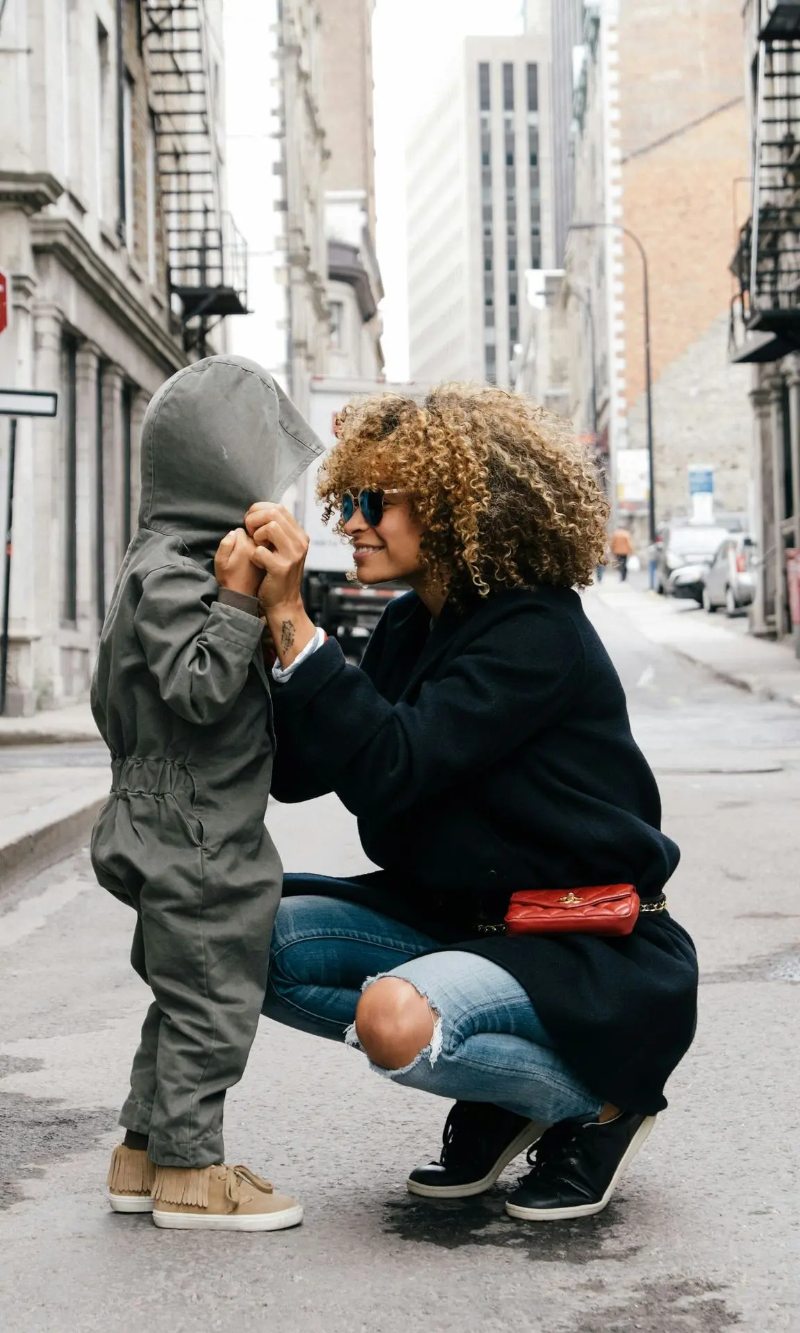 woman holding kid at the street